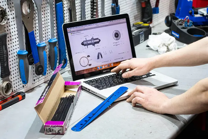 a man working on a laptop computer surrounded by tools